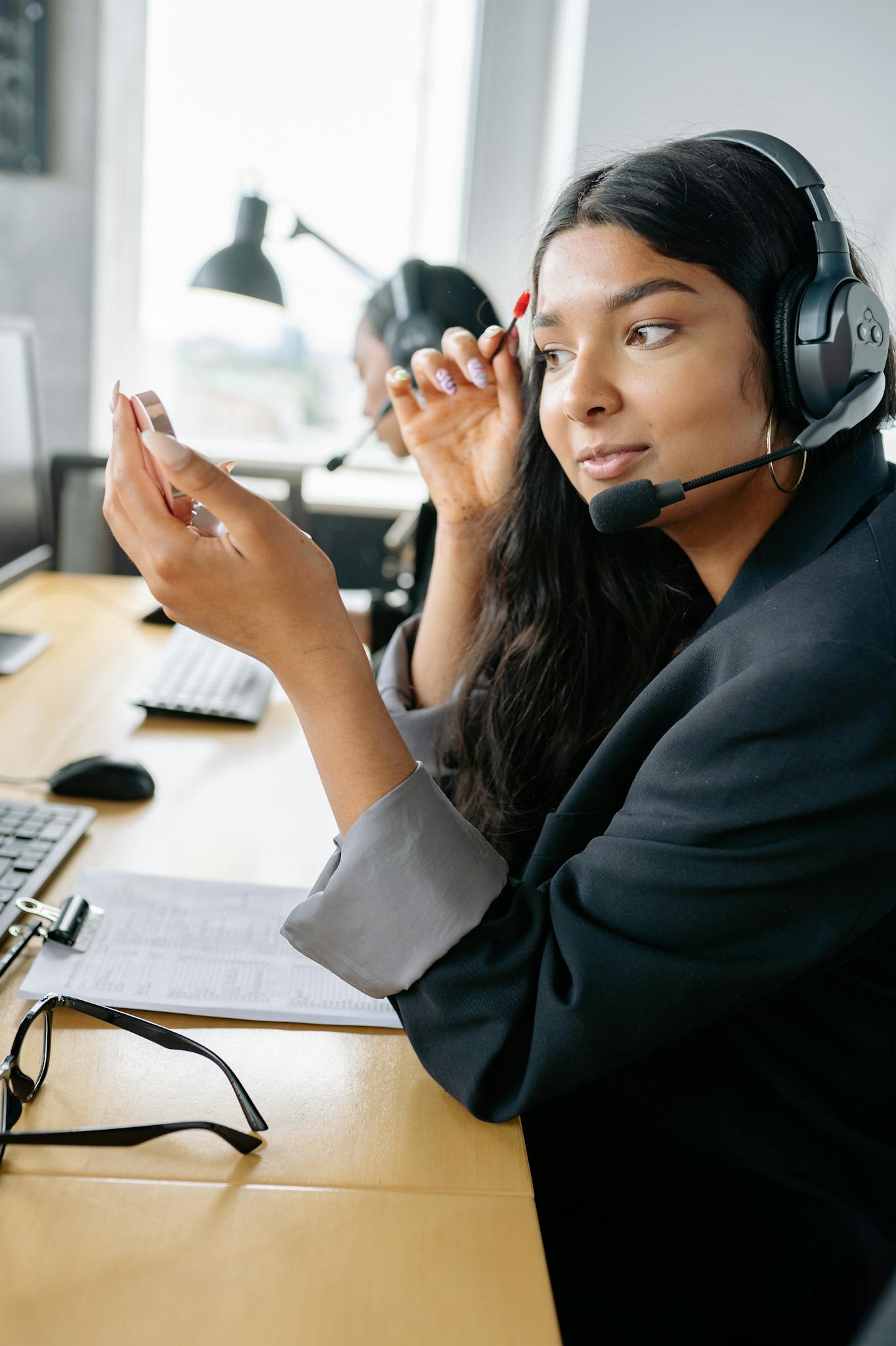 Young woman with headset working in a modern office, focused and engaged in her task.